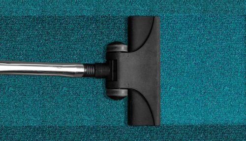 stick vacuum on a blue carpet