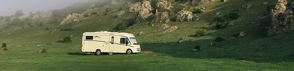 RV being powered by a camping generatornext to a grassy hill