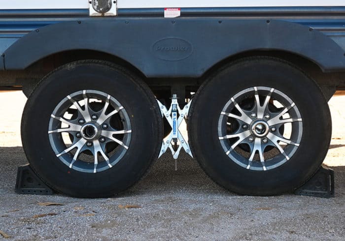 solid rubber rv wheel chocks and x-chock on tandem travel trailer