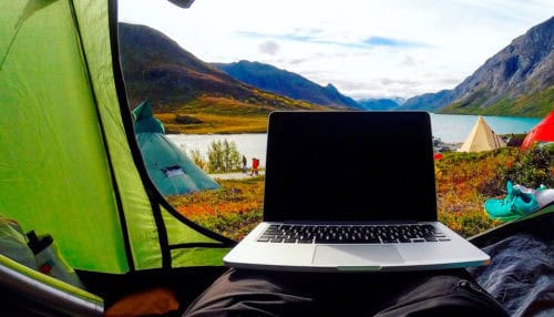 Laptop being charged with a portable power station while tent camping