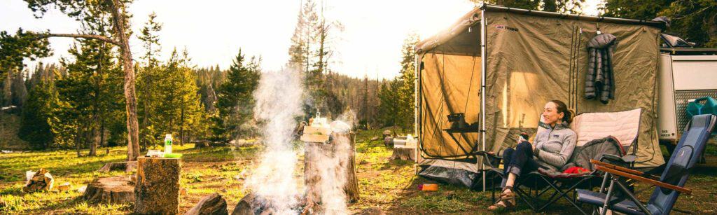 Pop up screen tent at a campsite next to a campfire