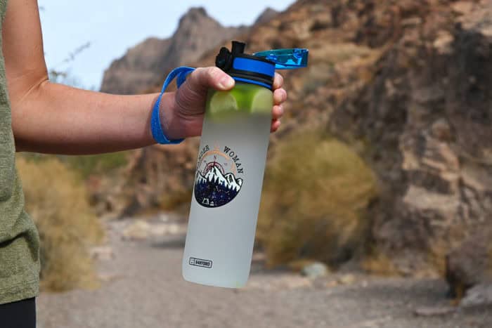 girl holding 64Hydro water bottle on a hike