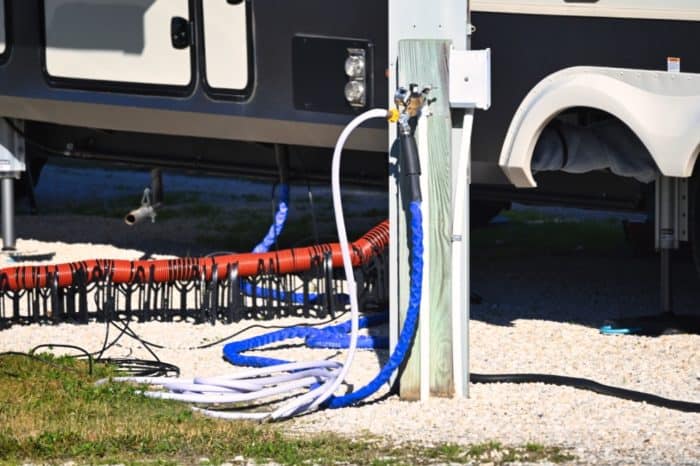camco heated rv water hose connected to a 5th wheel camper trailer at an rv park