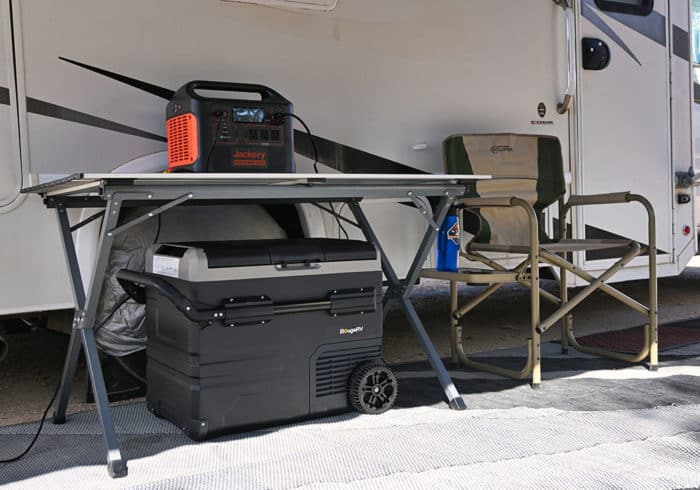 BougeRV CR45 portable fridge freezer under a camping table plugged into a Jackery 1500 portable power station