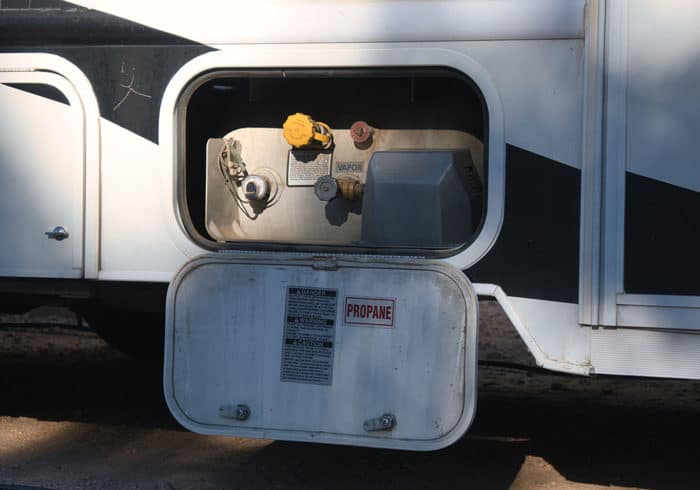 entry door and valves of a permanently mounted asme propane tank on a motorhome