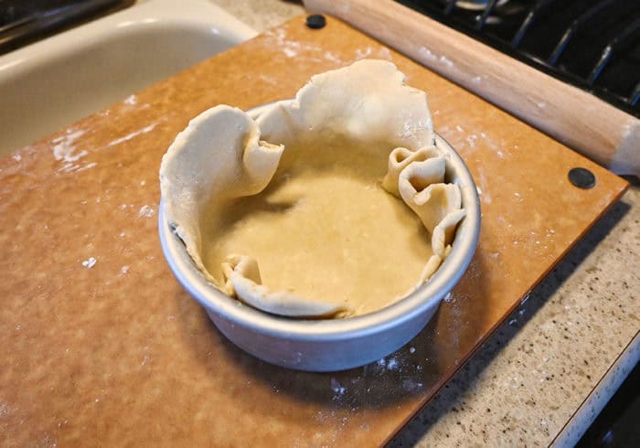 small cake pan for a mini air fryer with uncooked pie dough inside