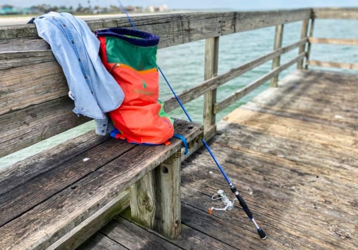 Cotopaxi 18L Luzon Del Dia Daypack next to some fishing gear on a pier