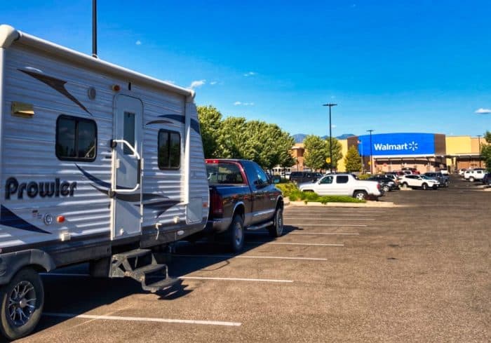 stealth camping outside a walmart in the parking lot with a travel trailer