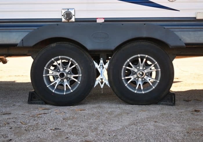travel trailer rv with wheel chocks placed before unhitching at an rv park campground