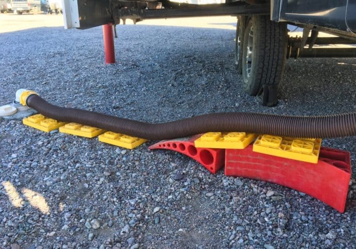 RV sewer hose stand made with RV leveling blocks and anderson levelers at RV park hookups