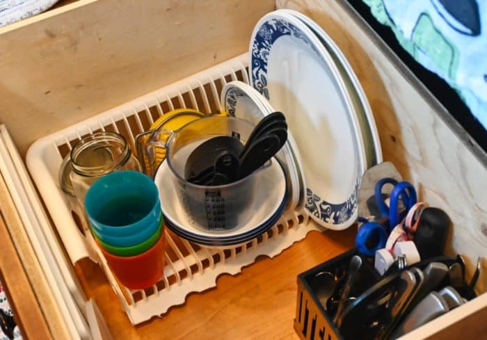 plates, bowles, and cups organized in an RV drawer in small motorhome kitchen