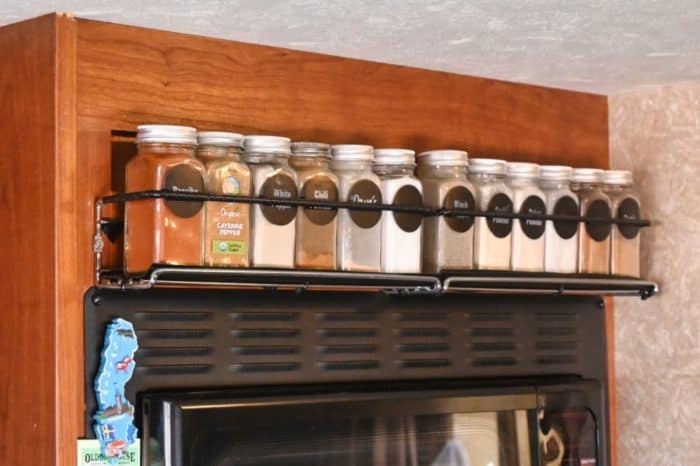 wall mount spice rack in a small rv kitchen above the microwave for organizing spices