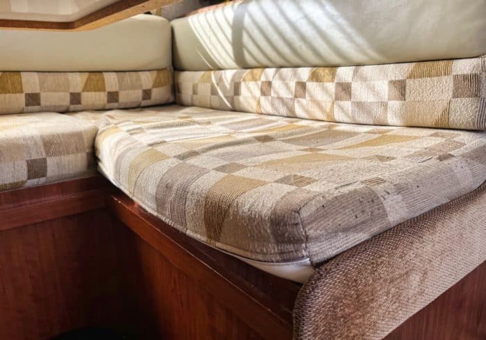old and worn rv cushion in a camper dinette