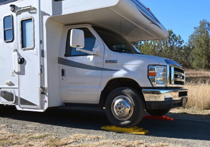 class c rv being leveled at a campsite using rv leveling blocks