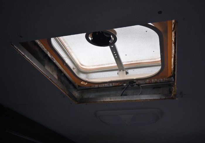 rv roof vent with the garnish ring removed and wires from a nearby light showing