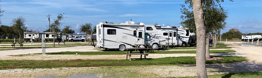 motorhome in an rv park with a charger connected between the rv house battery and rv chassis battery