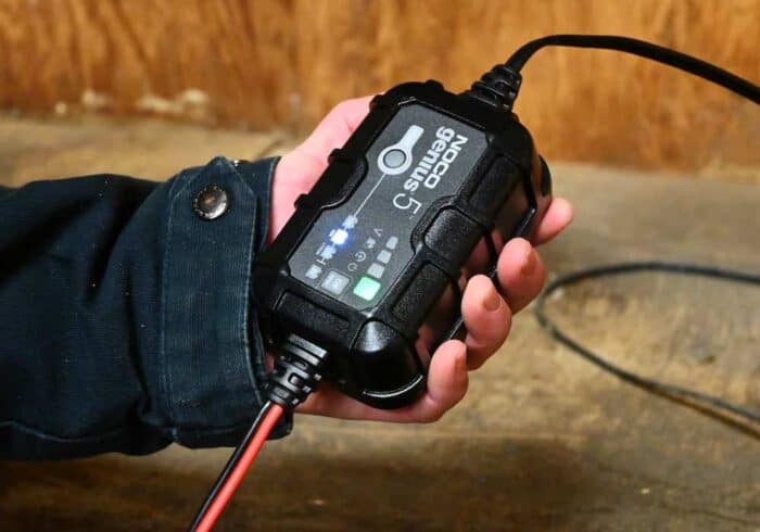 NOCO Genius 5 amp smart battery charger being held in a hand