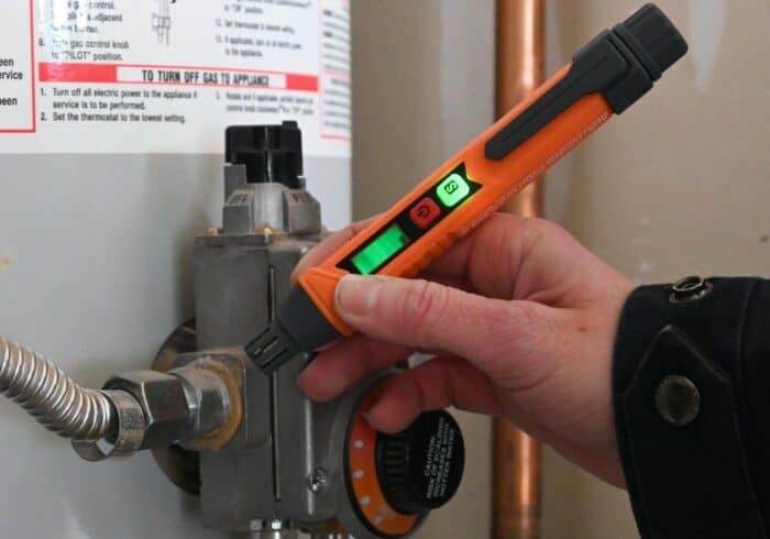 testing a natural gas pipe connection on a water heater for leaks with a toptes combustible gas detector