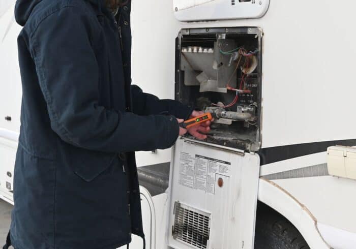 checking for propane leaks behind an rv propane fridge with a toptes portable combustible gas detector