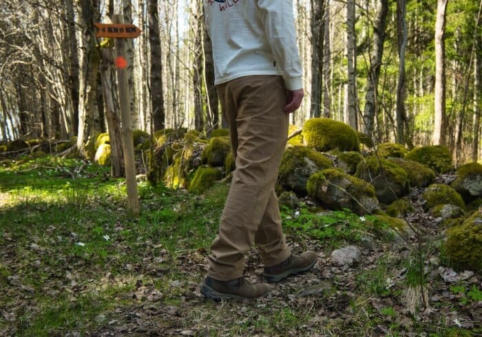 hiking through a forest wearing kühl free radikl mens hiking outdoor pants