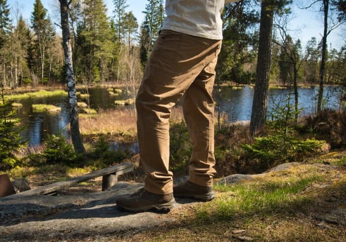 kuhl free radikl men's hiking pants being worn on a hike next to a lake