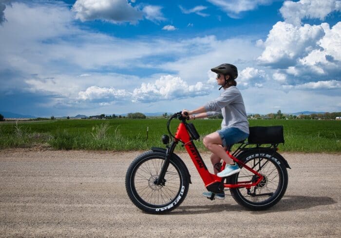 woman riding the Rattan Pathfinder ST fat tire electric bicycle on a dirt road