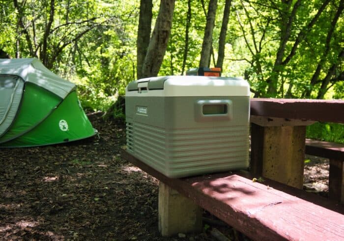 Aaobosi 30 liter portable fridge on a picnic table in a campsite