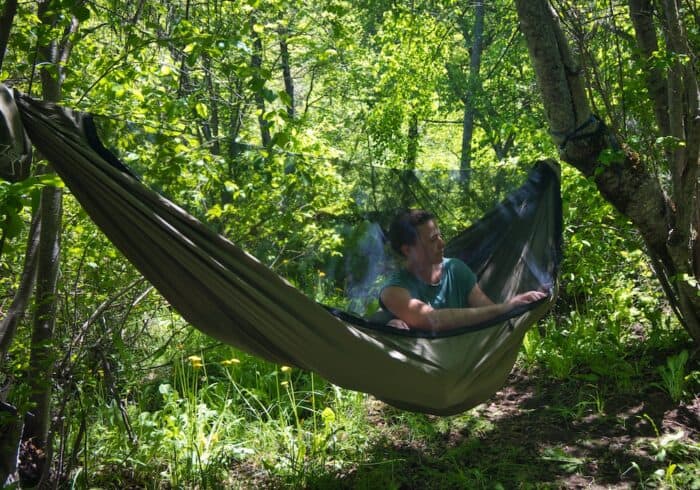 zipping up the bug net while inside the OneWind Northers zippered double hammock 