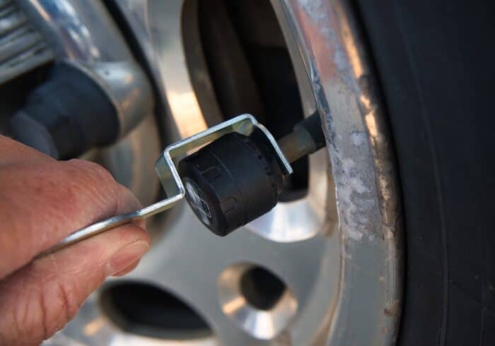 anti-theft nut being tightened to the back of the GUTA rv tire pressure monitoring system sensor. 