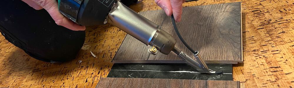 Vevor plastic welding gun being used to weld plastic flooring.