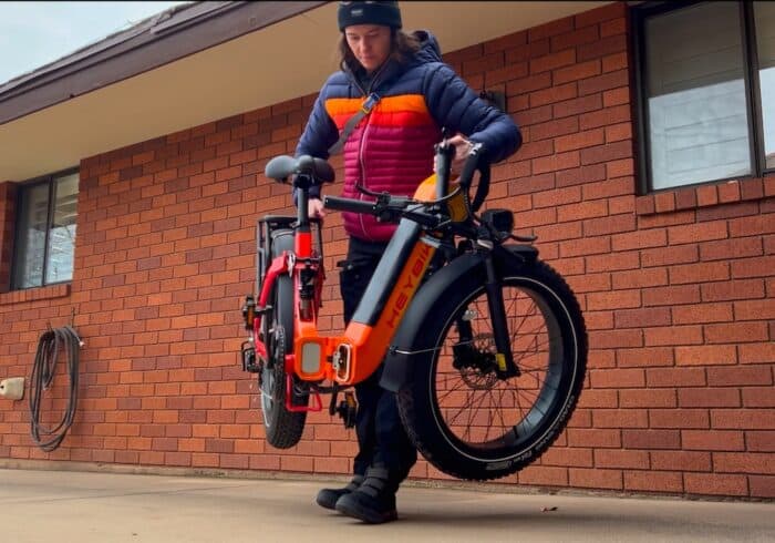 woman lifting and unfolding the HeyBike Horizon limited edition folding full suspension electric bike